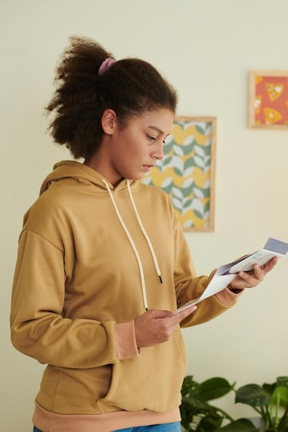 A close-up of a young person holding a digital ID document displayed on their smartphone, showcasing their name, photo, and ID Jovem status. The background is blurred, suggesting a bustling urban environment.