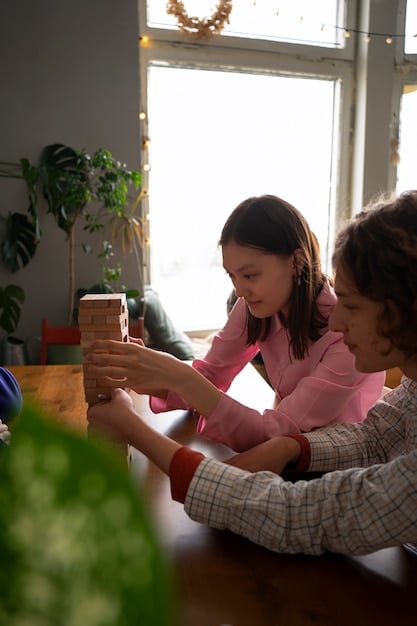 A social worker is playing with a child inside her house, with the Child Happy program booklet beside them.