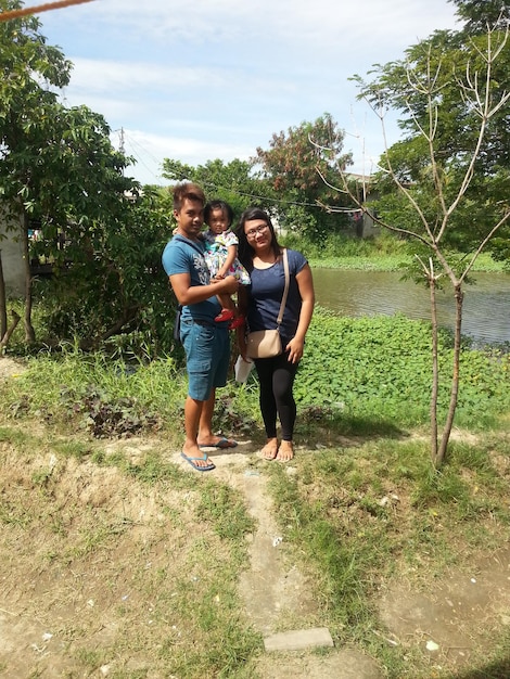 A smiling Brazilian farming family standing in front of their newly constructed or renovated rural home, showing the positive impact of the PNHR program.