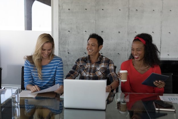 Three smiling people working together at a table, surrounded by laptops and documents related to social impact measurement. The setting is a bright and modern office space, suggesting a professional and well-organized approach to impact assessment.