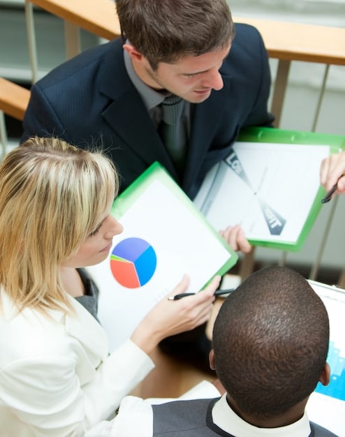 A medium shot captures a diverse team member presenting community project financial report, highlighting the impact towards goals, in a transparent and approachable manner during a project update meeting in a bright, modern office to donors.