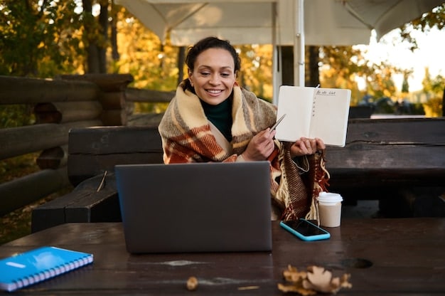 A Brazilian volunteer using a laptop and researching volunteer opportunities online, with a map and travel brochures in the background.
