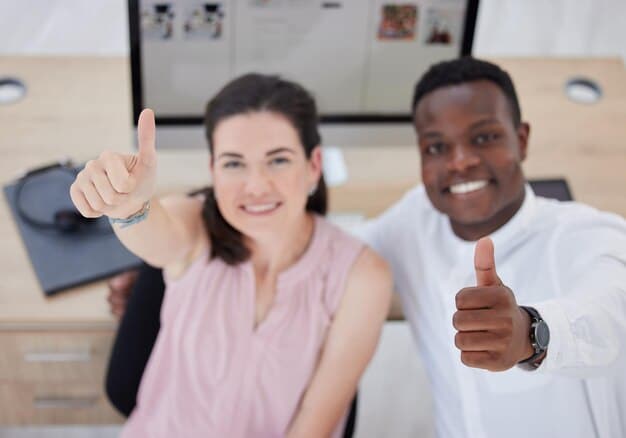Two people smiling and giving a thumb up sign to the camera. They are in a modern and bright home office environment. Both are wearing casual clothing, creating a relaxed atmosphere.
