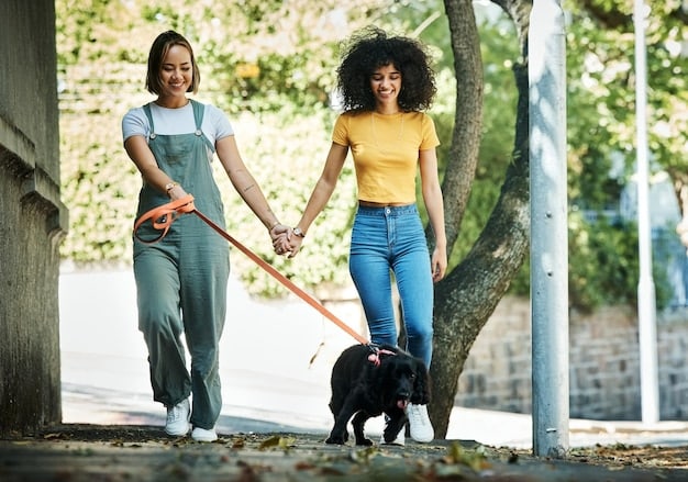 A volunteer smiling and walking a dog on a leash at an animal shelter. Other animals are visible in the background.