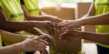 Mãos diversas de voluntários trabalhando em conjunto em uma pequena ONG brasileira, simbolizando colaboração e dedicação.